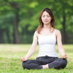 Orang sedang meditasi di lingkungan alam yang tenang